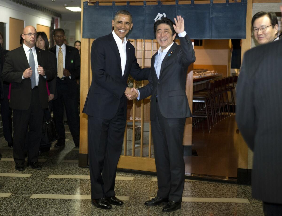 President Obama and Japanese Prime Minister Shinzo Abe shake hands before having dinner at the Sukiyabashi Jiro sushi restaurant in Tokyo.