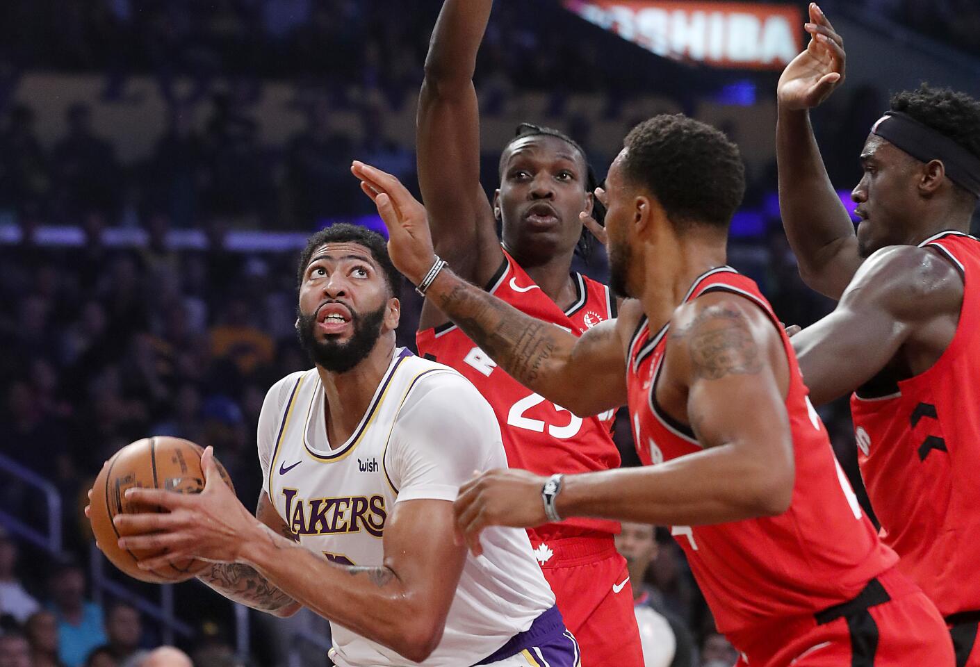 Lakers forward Anthony Davis draws a trio of Toronto defenders as he looks to score down low during the first half.