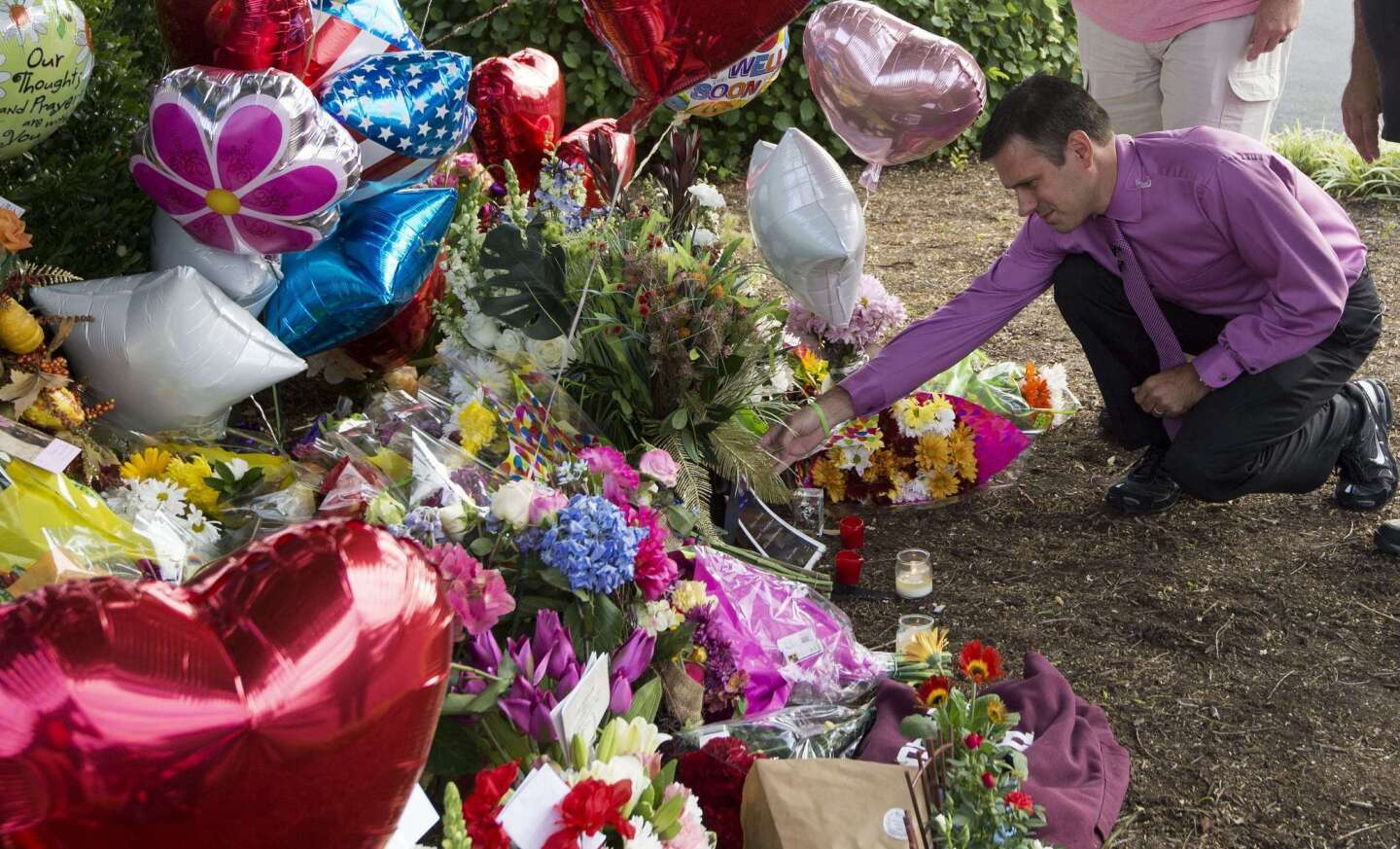 WDBJ-TV weatherman Leo Hirsbrunner views the makeshift memorial at the gate of WDBJ's television studios in Roanoke, Va. The former TV reporter suspected of shooting and killing two other journalists during a live broadcast before killing himself warned that he had been a "human powder keg ... just waiting to go BOOM."