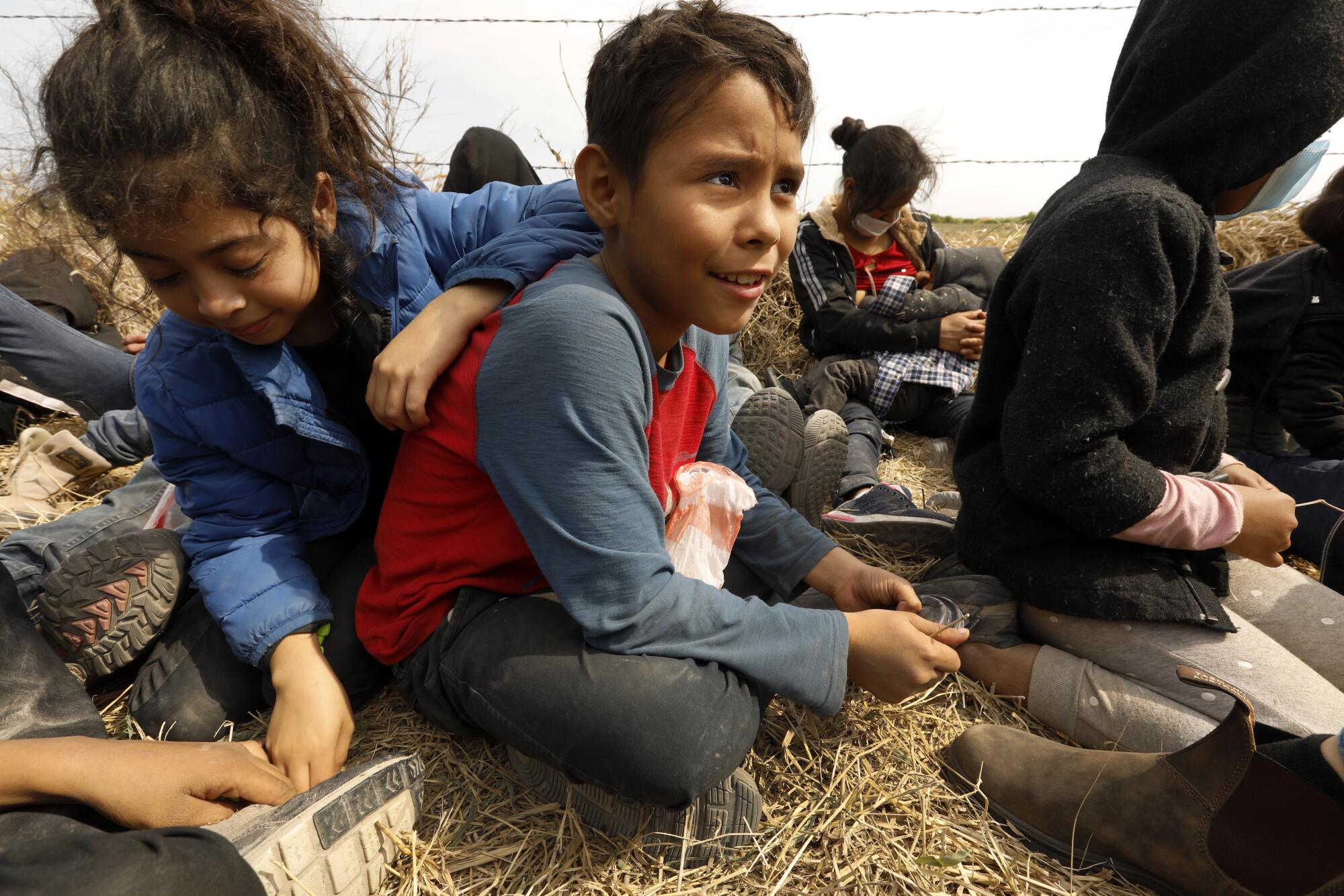 Christopher Garcia, 10, center, sits with fellow Central American migrants in Texas' Rio Grande Valley.
