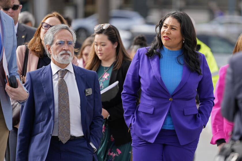 San Francisco Mayor London Breed, right, walks with Board of Supervisors President Aaron Peskin to a news conference to address sea level rise along the city's waterfront in San Francisco, Friday, Jan. 26, 2024. (AP Photo/Eric Risberg)