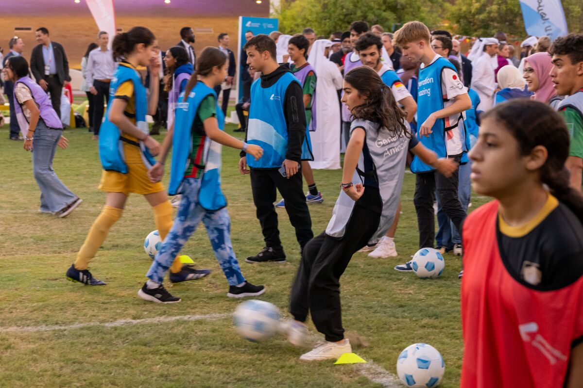 Young soccer players kicking balls at a sports diplomacy event 