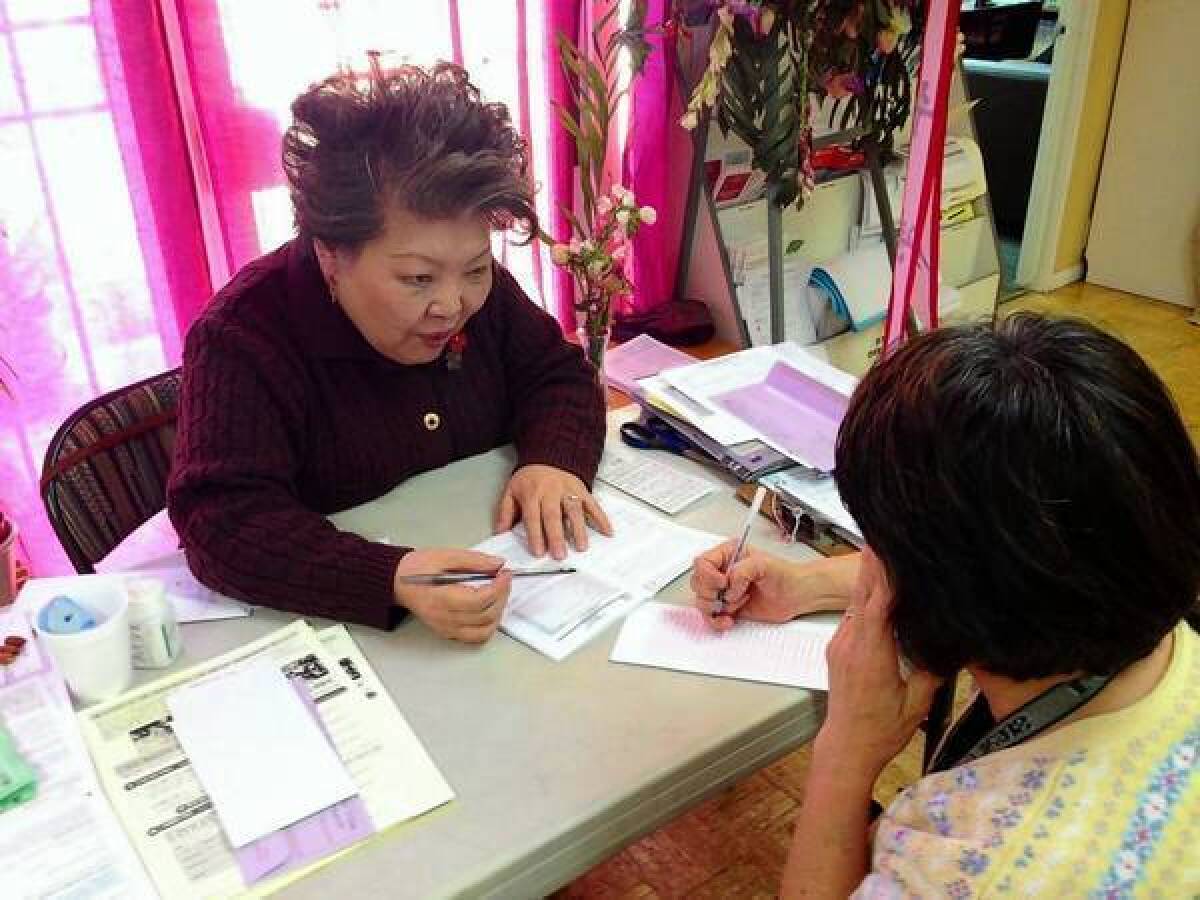 Grace Yi, a volunteer at the Korean Resource Center in Koreatown, helps a client fill out a ballot. Last year, she called 3,000 people to ask them to vote.