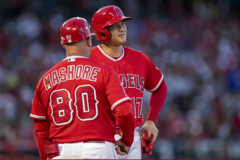 Los Angeles Angels designated hitter Shohei Ohtani, right,, talks with first base coach Damon Mashore.