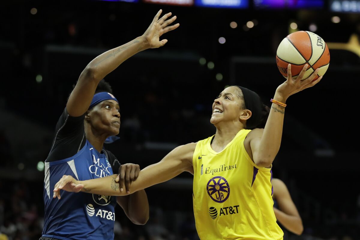 FILE - In this Aug. 20, 2019, file photo, Minnesota Lynx center Sylvia Fowles, left, fouls Los Angeles Sparks forward Candace Parker during the second half of a WNBA basketball game in Los Angeles. Parker and her 11-year-old daughter are braving the start of an unprecedented WNBA season together in Florida. The Sparks All-Star knows it’s a calculated risk to stay in the coronavirus hot spot, where all 12 teams will play games in the WNBA “bubble” of Bradenton. (AP Photo/Chris Carlson, File)