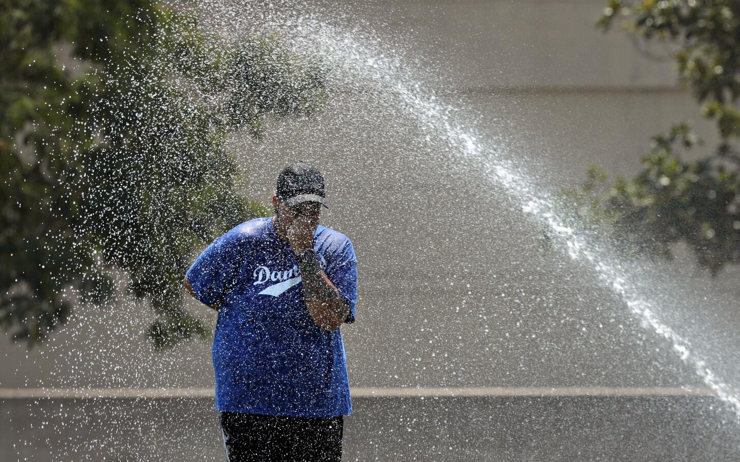 Reana Gallardo cools off in the sprinkler at Mason Park in Chatsworth