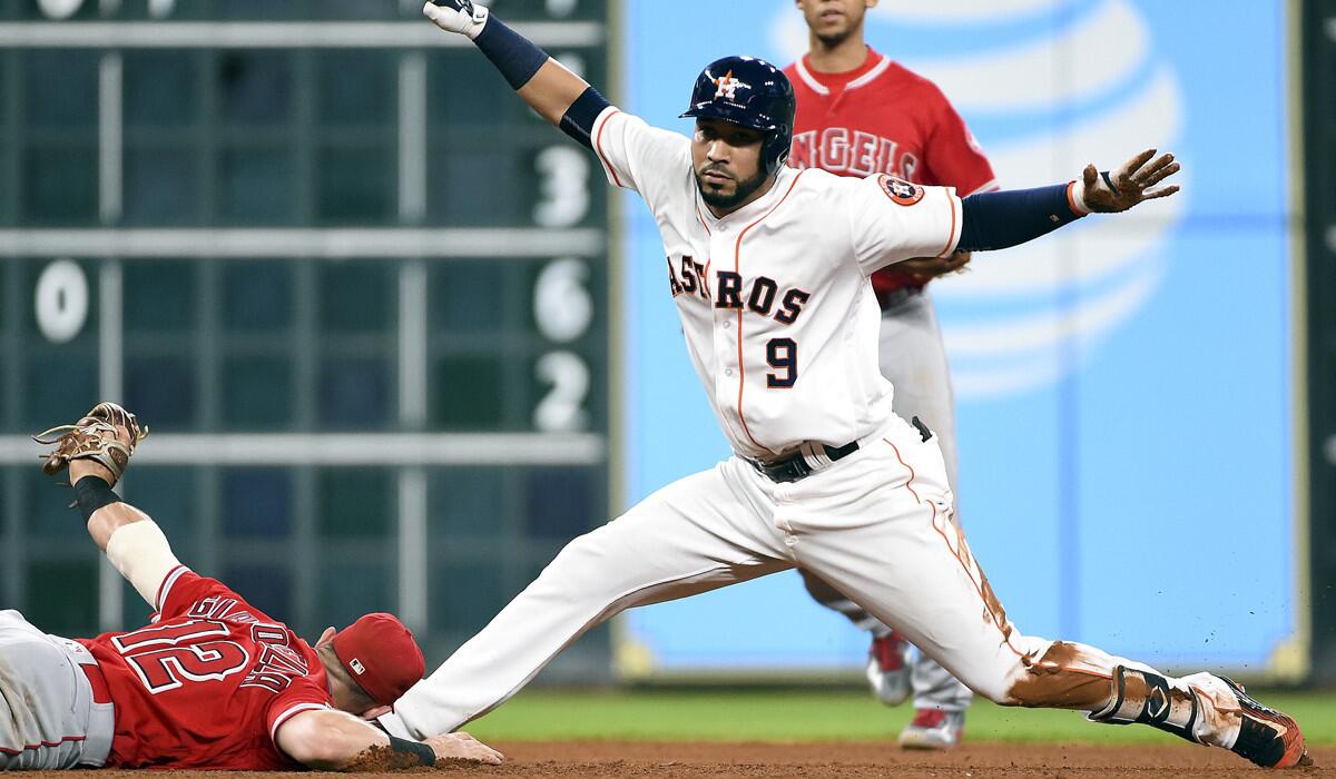 Houston Astros' Marwin Gonzalez signals himself safe after hitting a double, beating the tag of Angels' Johnny Giavotella during the seventh inning on Tuesday.