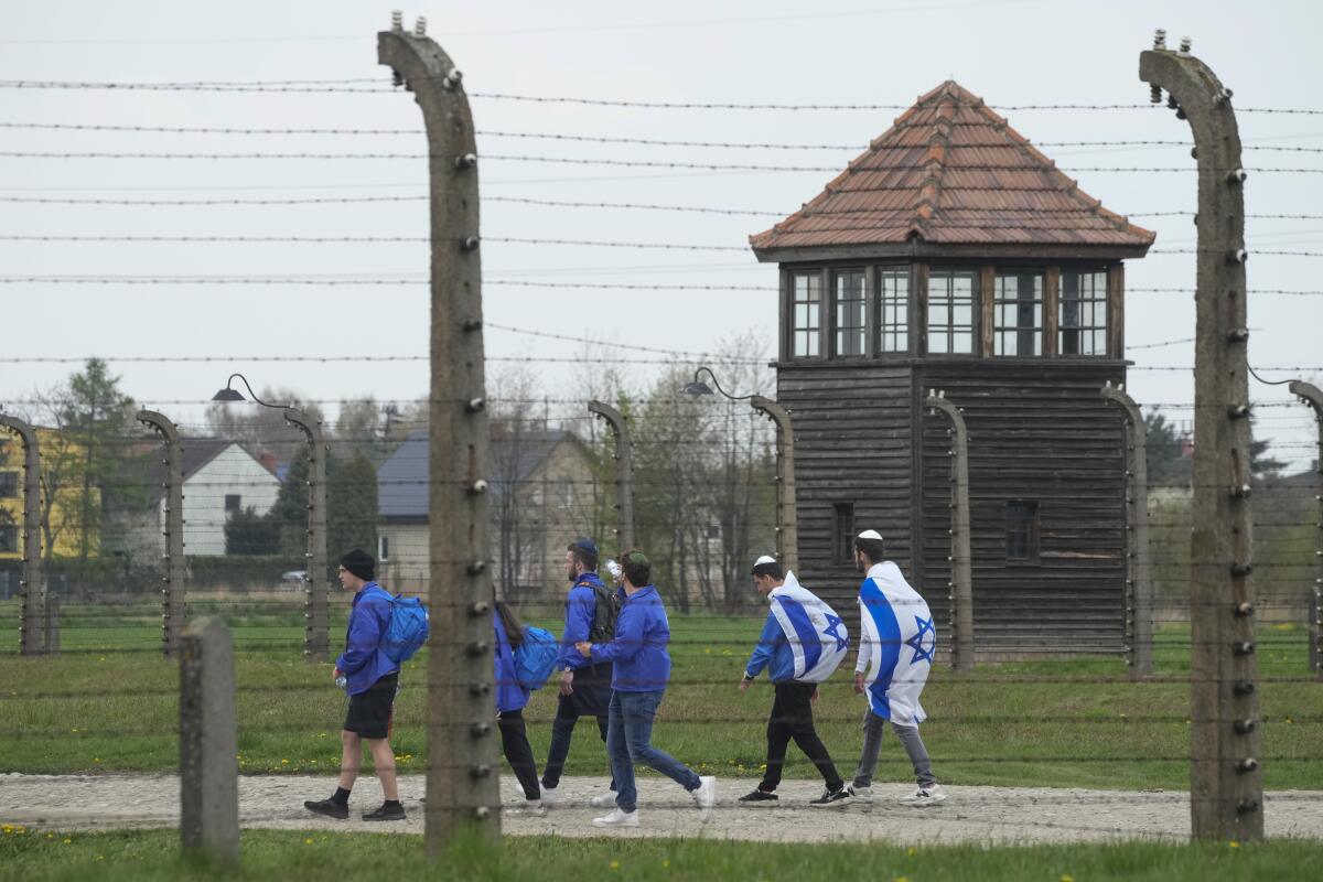 FILE - Jewish people visit the Auschwitz Nazi concentration camp after the March of the Living annual observance, in Oswiecim, Poland, April 28, 2022. The Polish government wants formal rules to regulate the terms under which Israeli schoolchildren pay Holocaust study visits to the country, including on the presence of armed Israeli guards, an official in Warsaw said Monday June 20, 2022. (AP Photo/Czarek Sokolowski, File)