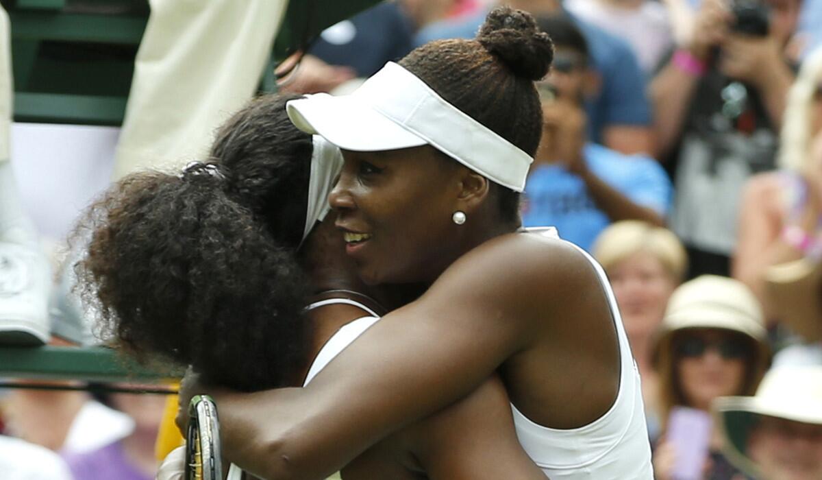 Serena Williams, left, hugs her sister Venus Williams after winning their singles match at Wimbledon on July 6.