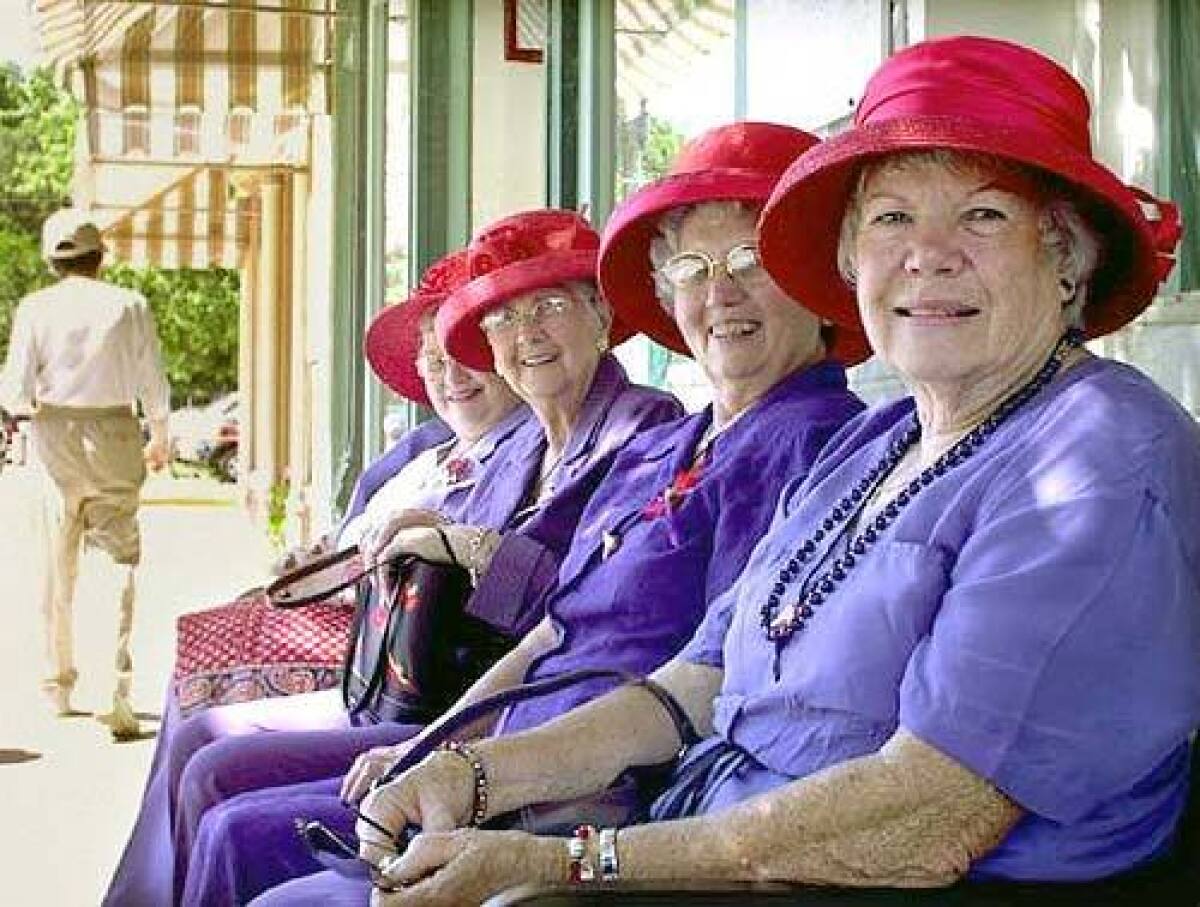 Ladies of the Red Hat Society from Hamilton, Ill., sit a spell on Main Street in Hannibal, Mo., a town of 18,000 that has retained much of its 19th century charm.