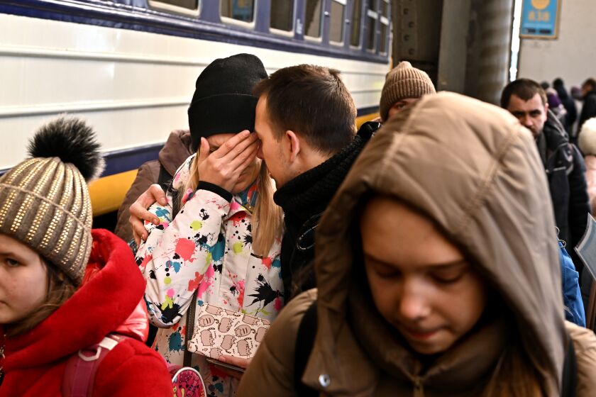 Lviv, Ukraine March 19, 2022: A man comforts his wife in Lviv, Ukraine before she boards a train to Przemysl, Poland. Over two million refugees have fled there towns after the Russians invaded. (Wally Skalij/Los Angeles Times)