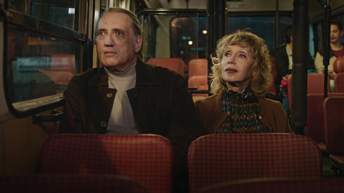 A man and a woman on a bus in the movie “Golden Voices.”