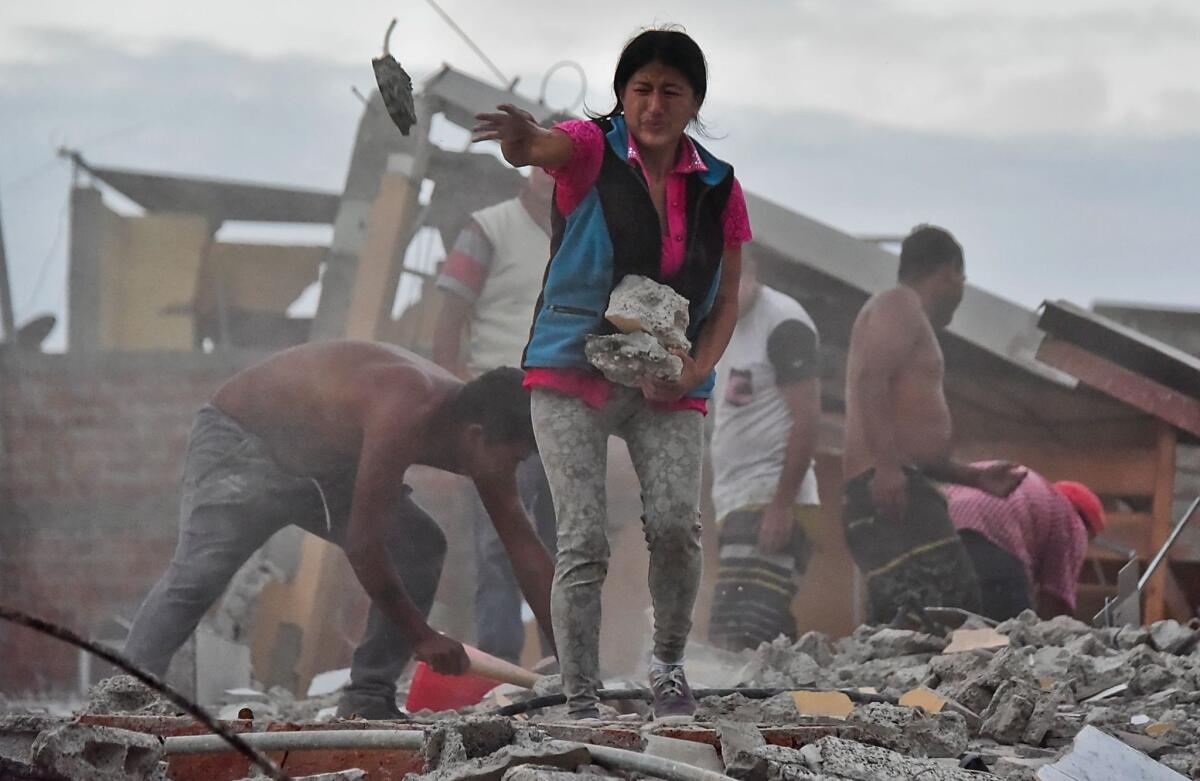 Veronica Paladines removes rubble in search for her husband in the Tarqui neighborhood in Manta, Ecuador, after a powerful quake hit the country.