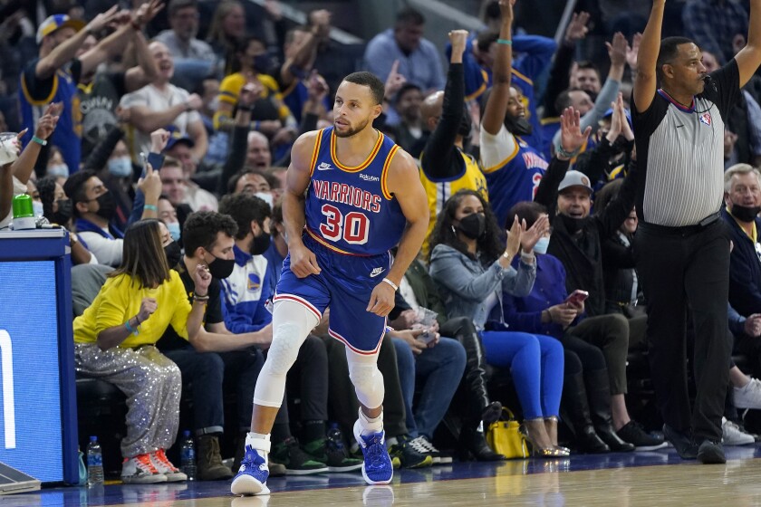 Golden State Warriors guard Stephen Curry (30) reacts in front of fans after shooting a 3-point basket against the Phoenix Suns during the first half of an NBA basketball game in San Francisco, Friday, Dec. 3, 2021. (AP Photo/Jeff Chiu)