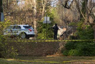 A member of the Arlington County Police Department looks towards the remains of a house explosion on Tuesday, Dec. 5, 2023, in Arlington, Va. (AP Photo/Kevin Wolf)