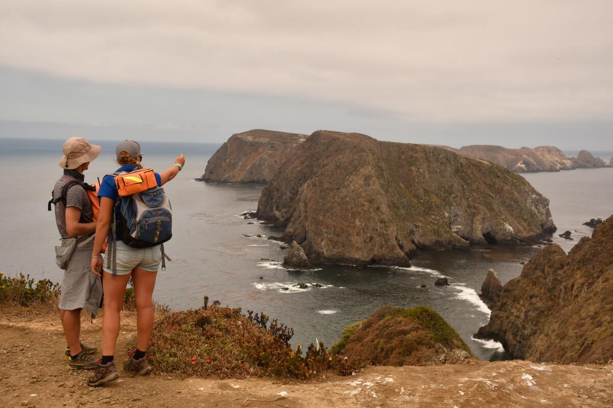 Hikers on Anacapa Island look from Inspiration Point to the island's central and western islets.  