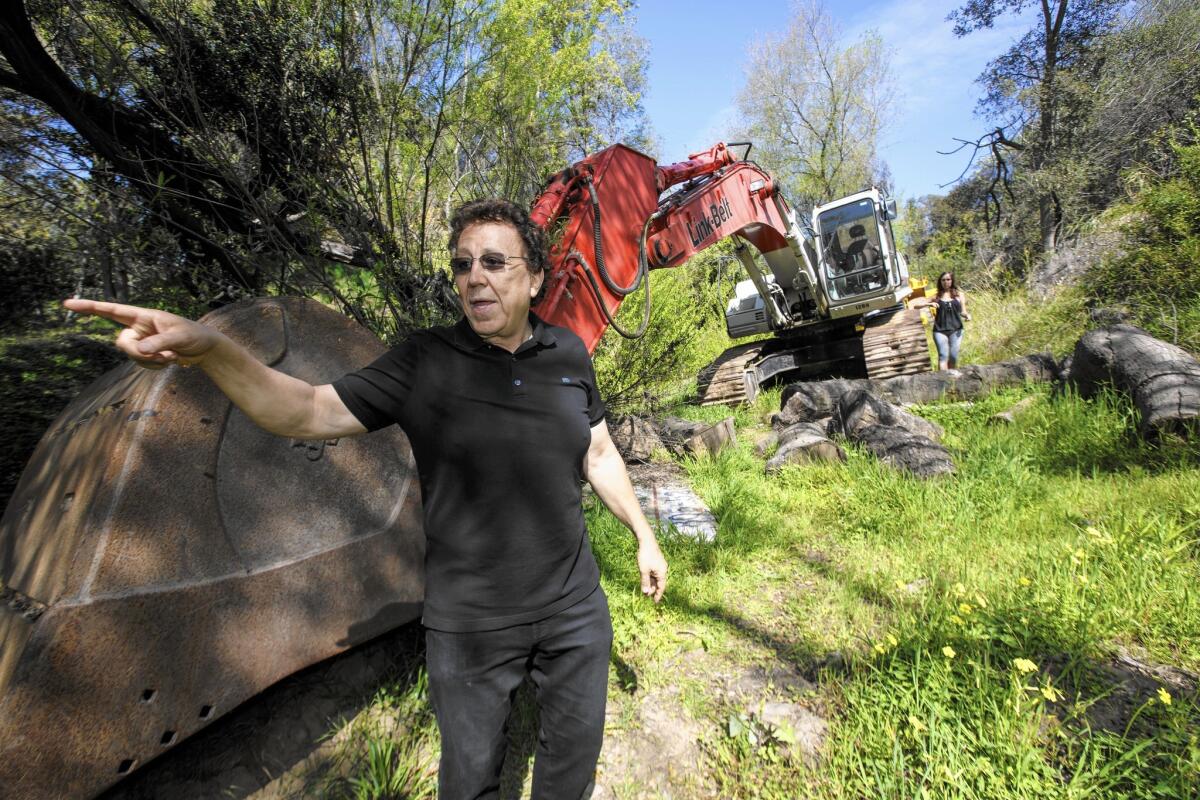 Sam Shakib stands next to an earthmover on his land. Brentwood neighborhood groups want the city to punish Shakib and his business partner, Sean Namvar, by revoking the permits for their planned 14,948-square-foot homes.