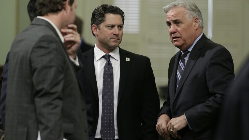 Republican Assemblymen James Gallagher, left, Jordan Cunningham and Jim Patterson huddle before voting on the state budget plan Thursday. GOP lawmakers provided only a few votes for the framework in both houses of the Legislature.