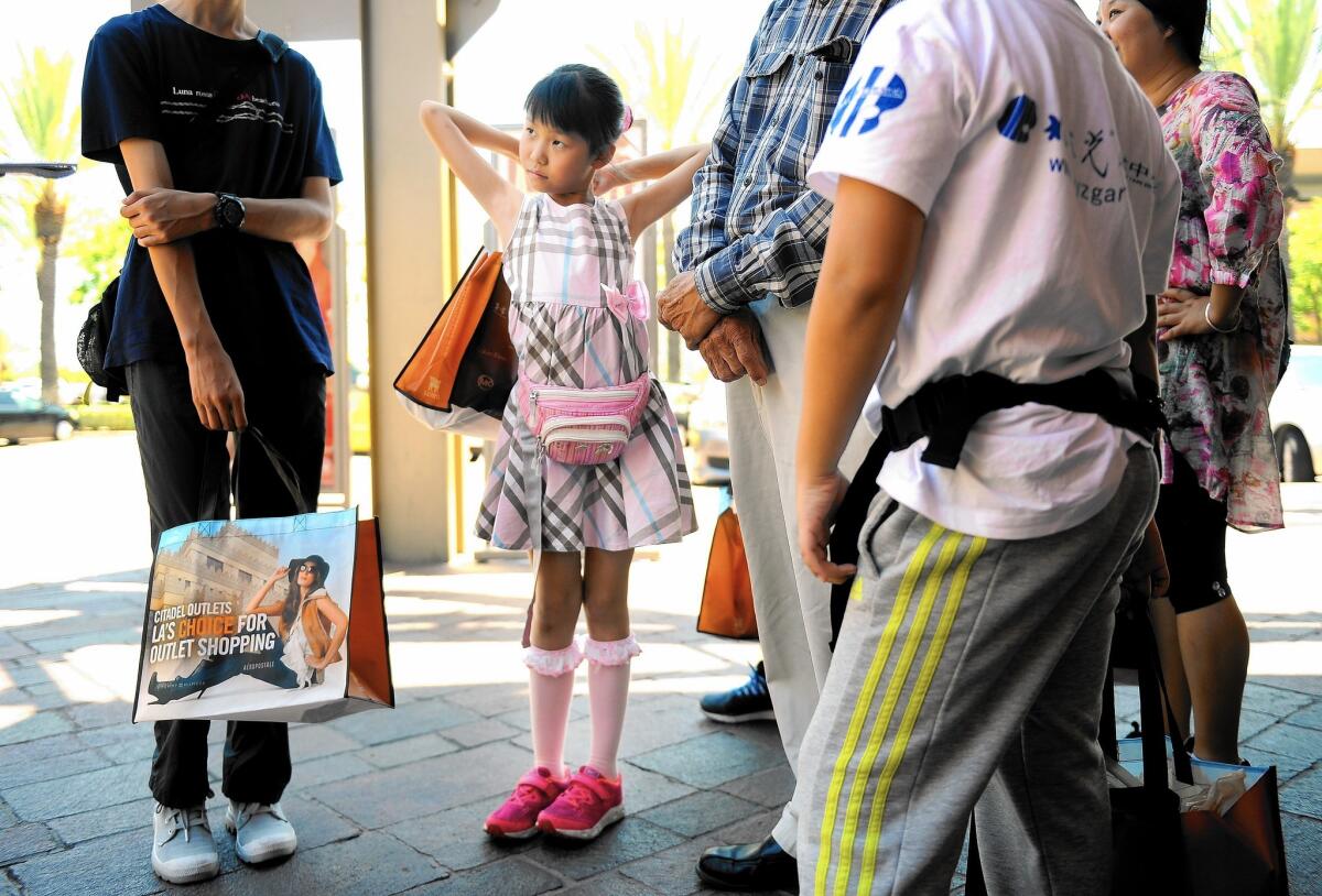 Tianyuan Chang, 9, and other Chinese tourists at the Citadel Outlets in Commerce on Wednesday.
