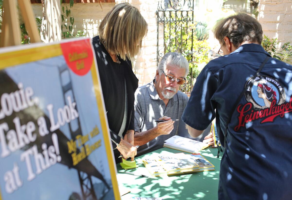 Luis Fuerte signs copies of his book "Louie, Take a Look at This!" at Sherman Library & Gardens Wednesday.