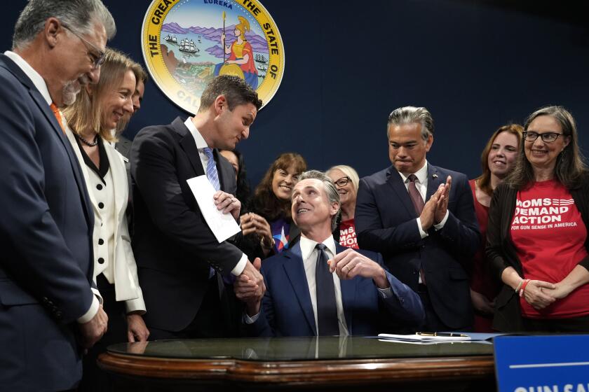 California Governor Gavin Newsom shakes hands with Assemblymember Jesse Gabriel, D-Los Angeles County, third from left, after signing Gabriel's bill that raises taxes on guns and ammunition, during a news conference in Sacramento, Calif., Tuesday, Sept. 26, 2023. (AP Photo/Rich Pedroncelli)