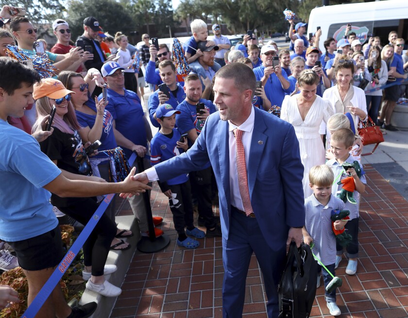 New Florida NCAA college football head coach Billy Napier shakes hands with fans as he and his family arrive at Ben Hill Griffin Stadium in Gainesville, Fla., Sunday, Dec. 5, 2021. [Brad McClenny/The Gainesville Sun via AP)