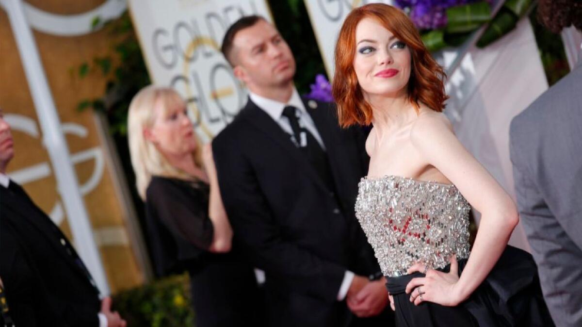 Emma Stone in a custom Lanvin jumpsuit, beaded on the strapless bodice and sashed and bowed at the waist, at the 2015 Golden Globe Awards.