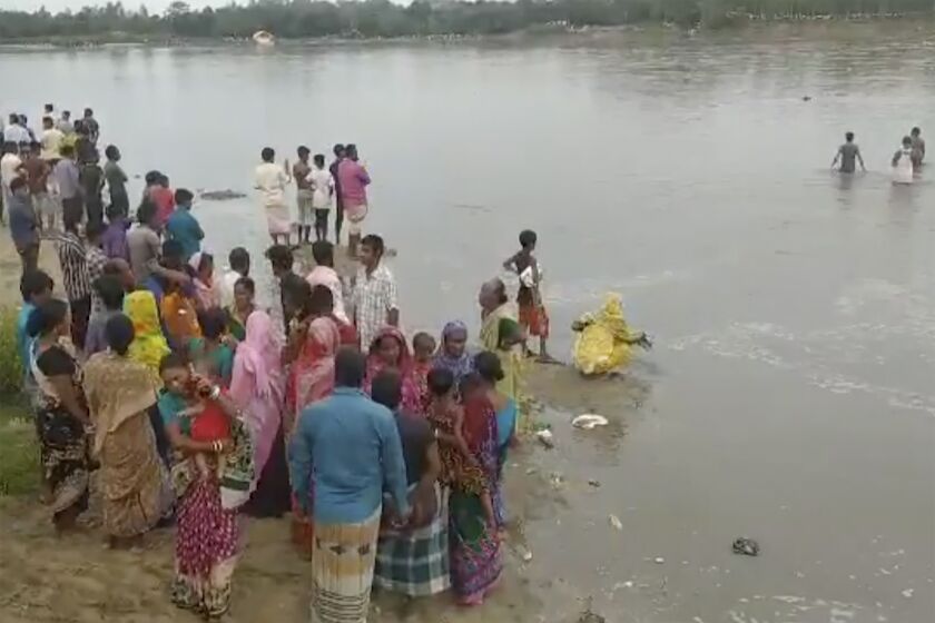 En esta imagen tomada de un video, varias personas buscan a sobrevivientes en el río Karatoa luego de que una embarcación sobrecargada naufragara allí el domingo 25 de septiembre de 2022, en Panchagarh, Bangladesh. (AP Foto)