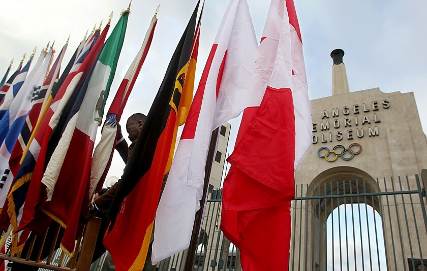 Flags representing the different countries participating in the Winter Olympic Games this year stand in front of the Los Angeles Memorial Coliseum in February.