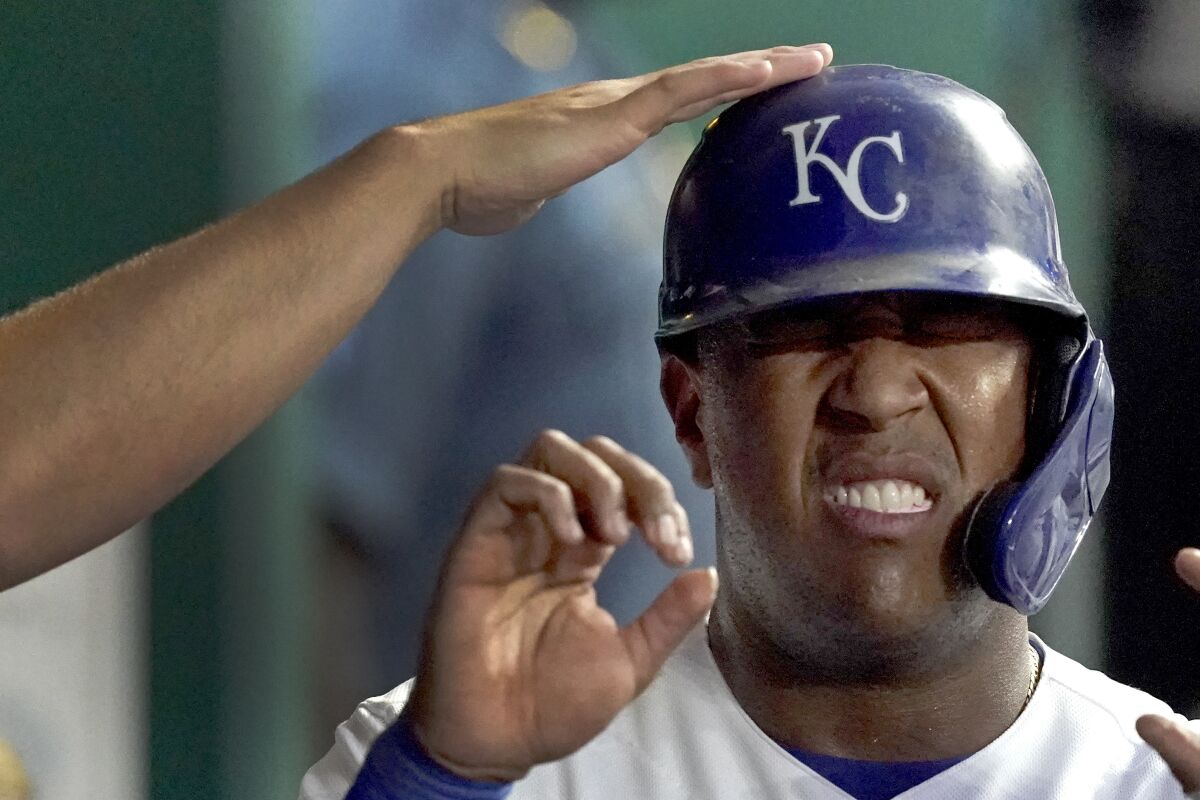 Kansas City Royals' Salvador Perez celebrates in the dugout after scoring on a single by Ryan O'Hearn during the third inning of a baseball game against the Houston Astros Monday, Aug. 16, 2021, in Kansas City, Mo. (AP Photo/Charlie Riedel)