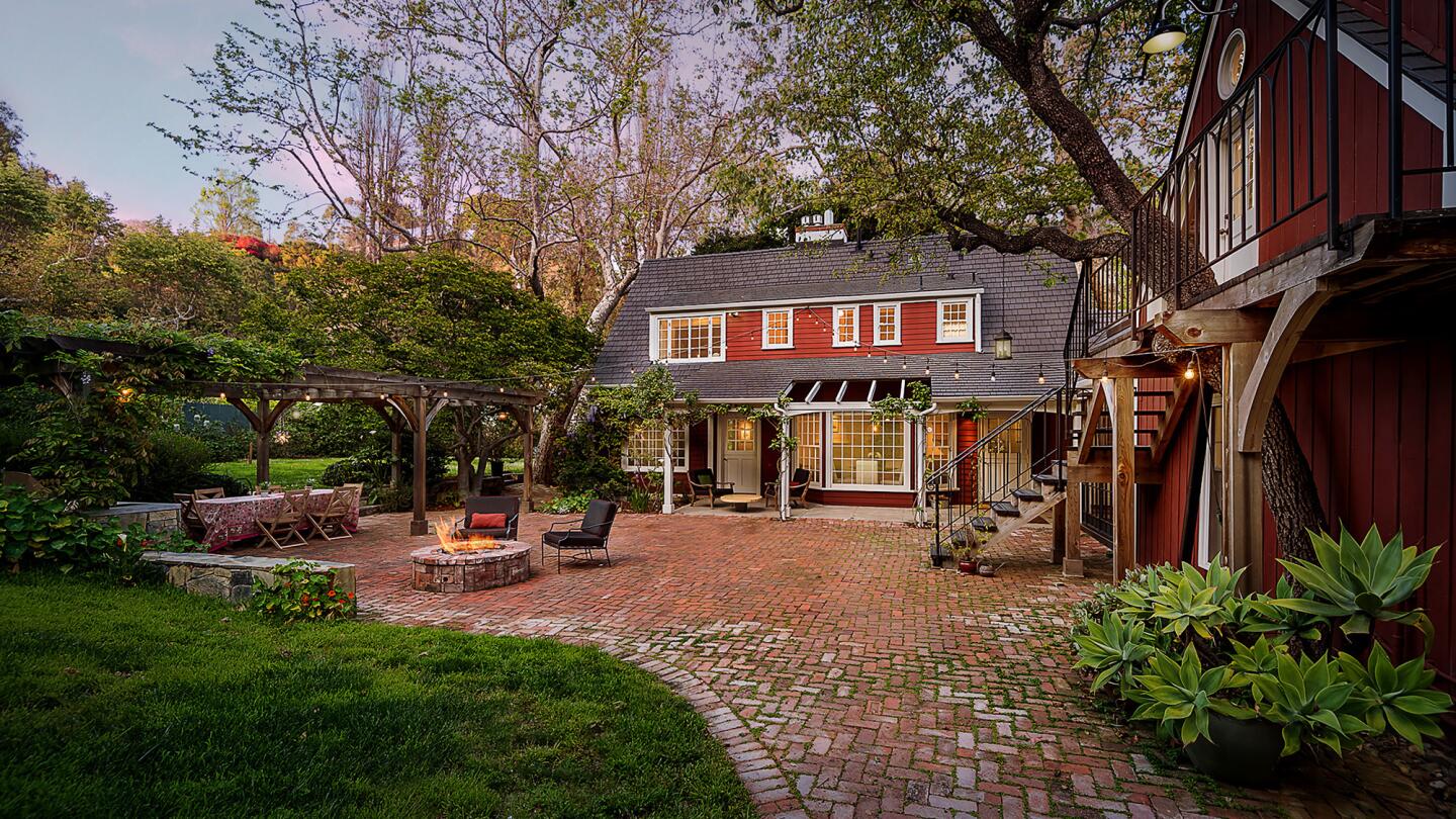 The 1940 "Red House," which has been renovated and restored, retains handcrafted wood details, wainscoting, wood floors and walls of windows overlooking gardens. Including the guesthouse, there are five bedrooms and six bathrooms within the 3,823 square feet of living space.