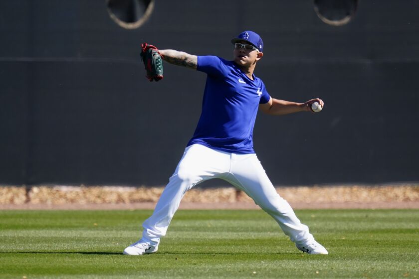 Los Angeles Dodgers pitcher Julio Urías warms up during a spring training baseball workout Sunday, March 13, 2022, in Phoenix. (AP Photo/Ross D. Franklin)
