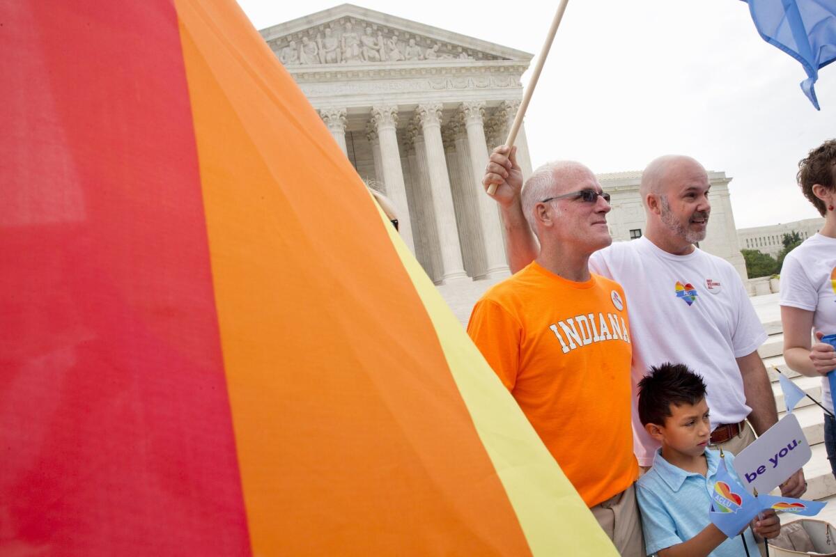 Rodney Moubray-Carrico and Scott Moubray-Carrico, who are among the Indiana plaintiff's, stand with their son Lucas, 7, outside of the Supreme Court in Washington on Friday. The Court narrowly affirmed, in occasionally eloquent terms, their right to be married.