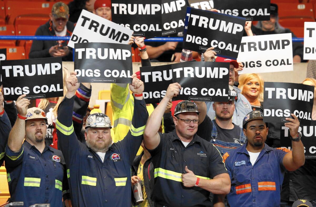 Coal miners wave signs at a Trump rally in Charleston, W.Va., in 2016.