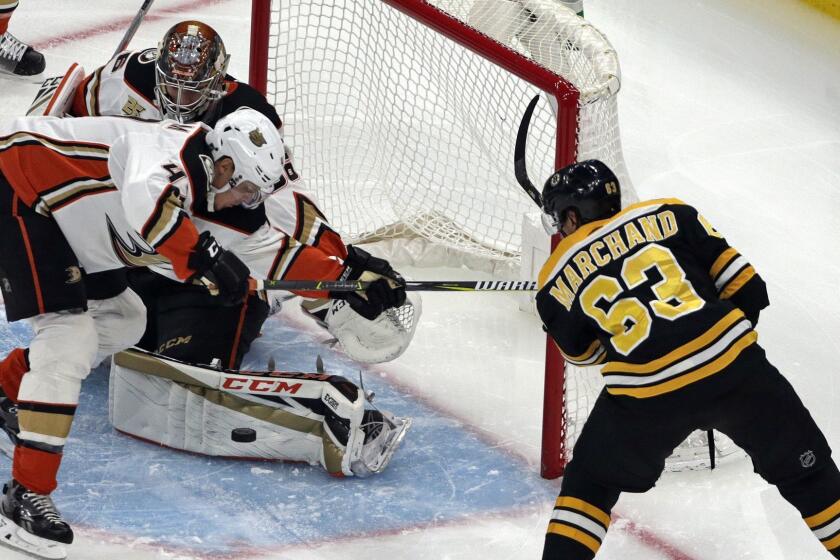 Anaheim Ducks goaltender John Gibson makes a save as defenseman Hampus Lindholm (47) helps defend against a shot by Boston Bruins left wing Brad Marchand (63) in the first period of an NHL hockey game, Thursday, Dec. 20, 2018, in Boston. (AP Photo/Elise Amendola)