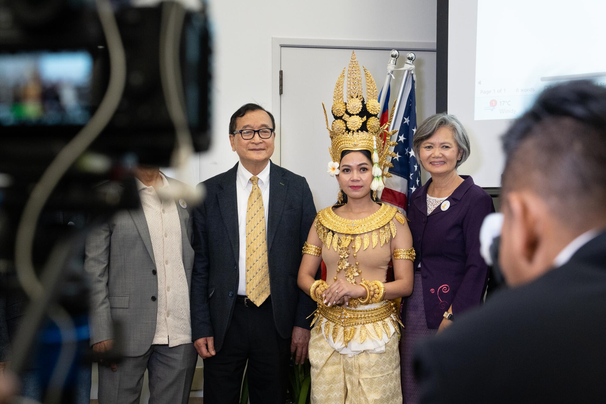 Sam Rainsy, left, and Mu Sochua, right, pose with an Apsara dancer.
