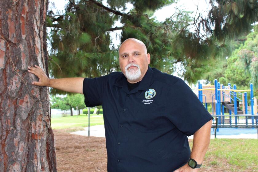 Costa Mesa Councilman Loren Gameros stands Thursday in Paularino Park, where large boulders installed on the playing field to keep people from playing team sports were recently removed.