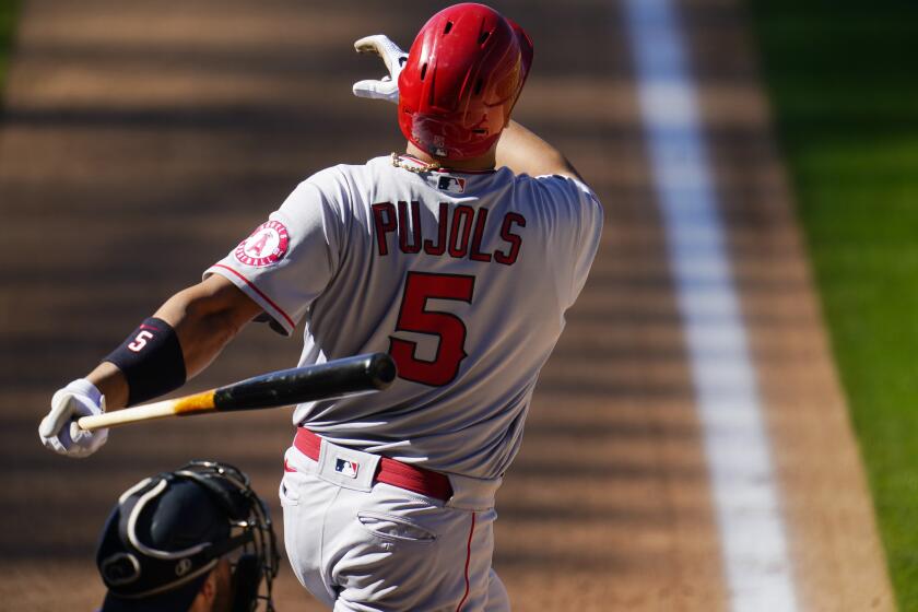 Los Angeles Angels' Albert Pujols follows the flight of his two-run home run off Colorado Rockies relief pitcher Carlos Estevez in the eighth inning of a baseball game Sunday, Sept. 13, 2020, in Denver. (AP Photo/David Zalubowski)
