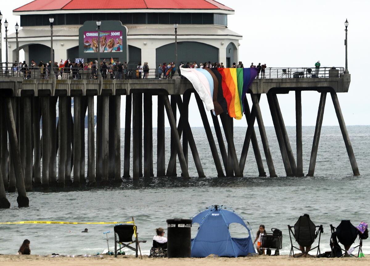 A giant Pride flag is hung off the north side of the Huntington Beach Pier on Sunday.