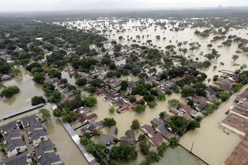 FILE - In this Aug. 29, 2017 aerial file photo, a neighborhood near Addicks Reservoir are flooded by rain from Harvey, in Houston. Houstonâs population is growing quickly, but when Harvey hit last weekend there were far fewer homes and other properties in the area with flood insurance than just five years ago, according to an Associated Press investigation. (AP Photo/David J. Phillip, File)