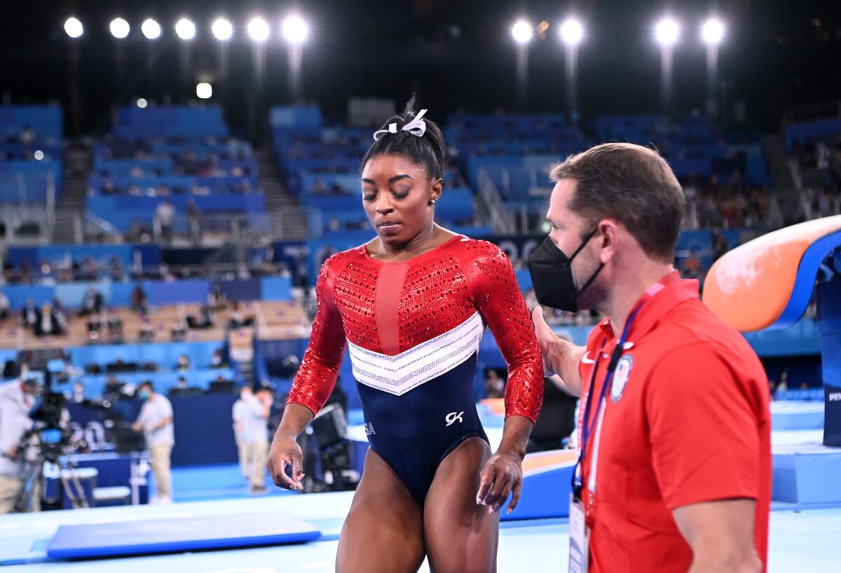 Simone Biles is helped away from the floor Tuesday at the Tokyo Olympics