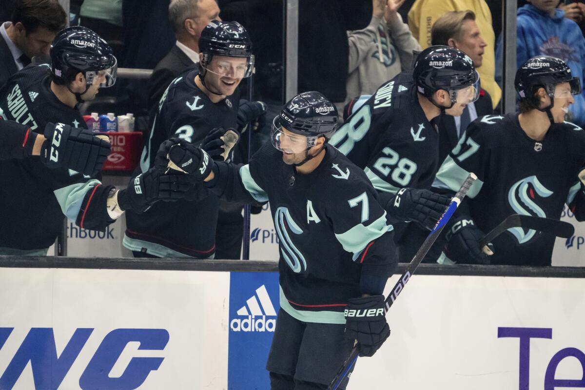 Seattle Kraken forward Jordan Eberle is congratulated by teammates on the bench after scoring a goal against the Nashville Predators during the first period of an NHL hockey game, Tuesday, Nov. 8, 2022, in Seattle. (AP Photo/Stephen Brashear)