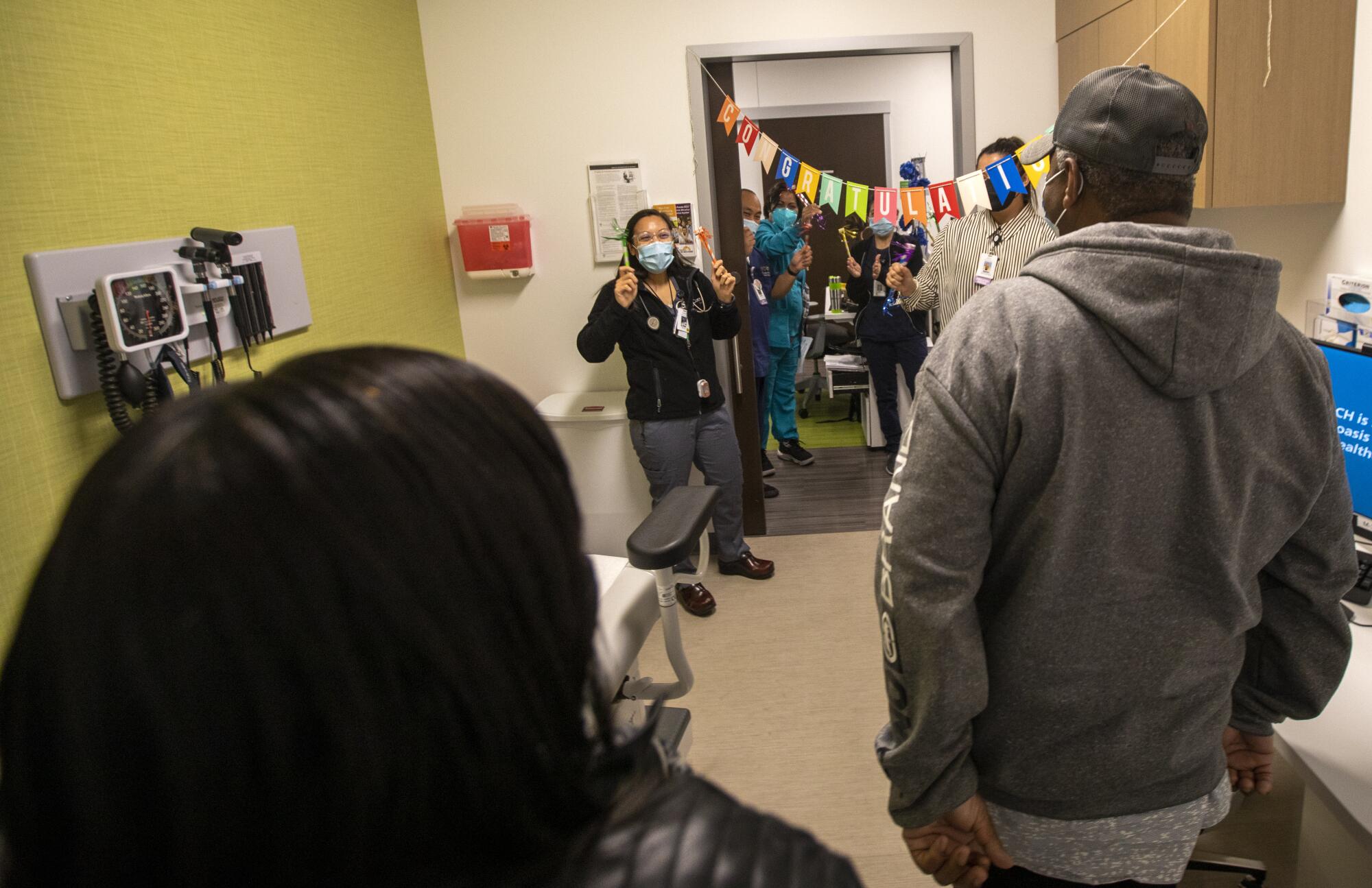 Richard and Audrey Perry walk into a clinic to a warm reception.