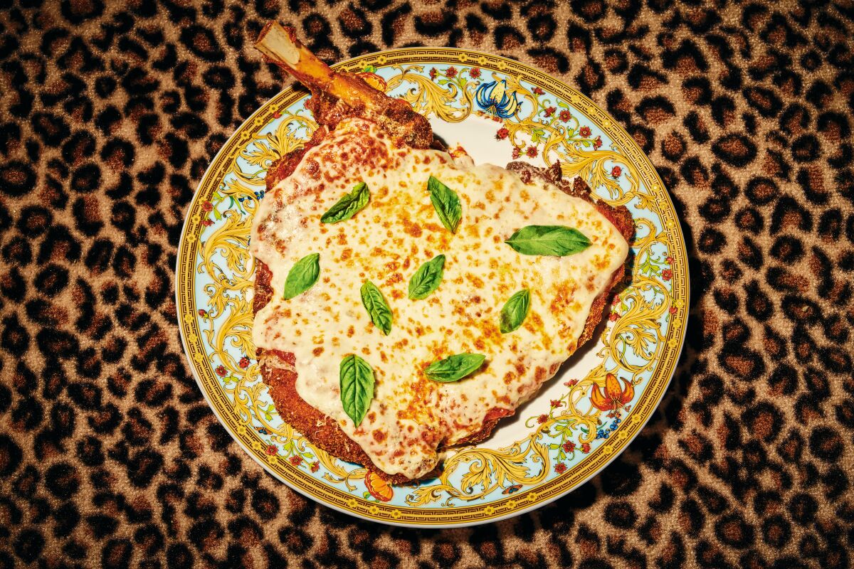 Bone-in veal Parmesan on a plate on a cheetah-print background