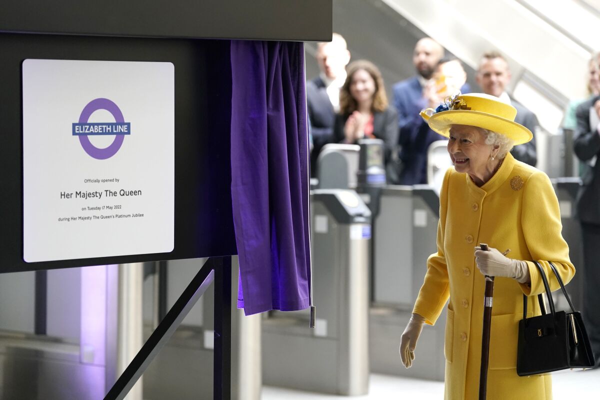 Britain's Queen Elizabeth II unveils a plaque to mark the Elizabeth line's official opening at Paddington station in London, Tuesday May 17, 2022, to mark the completion of London's Crossrail project. (Andrew Matthews/Pool via AP)