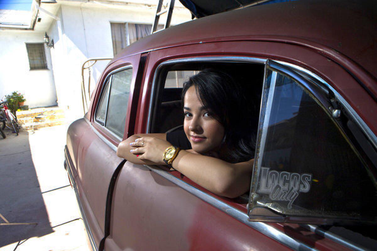 Talented young performer Becky G sits in a vintage Mercury being restored at her grandmother's house.