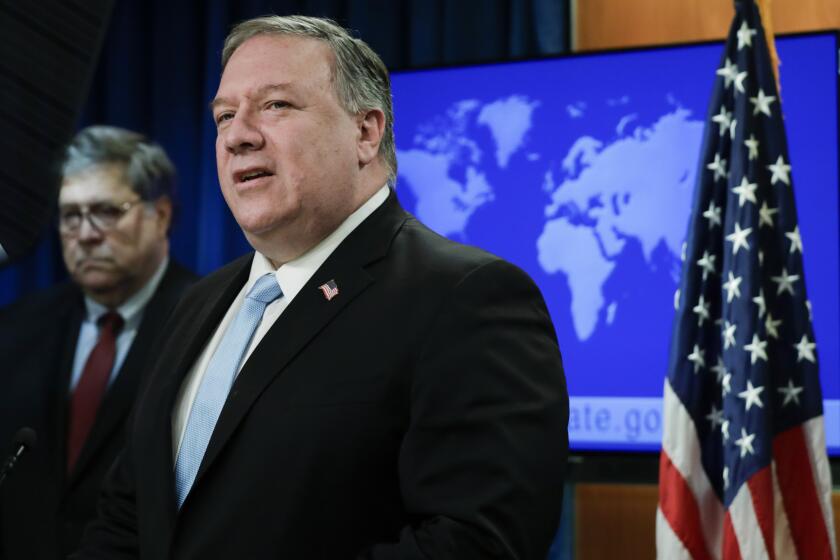 Secretary of State Mike Pompeo speaks as Attorney General William Barr listens, during a joint briefing, Thursday, June 11, 2020 at the State Department in Washington, on an executive order signed by President Donald Trump aimed at the International Criminal Court. Trump has lobbed a broadside attack against the International Criminal Court. He's authorizing economic sanctions and travel restrictions against court workers directly involved in investigating American troops and intelligence officials for possible war crimes in Afghanistan without U.S. consent. The executive order Trump signed on Thursday marks his administration’s latest attack against international organizations, treaties and agreements that do not hew to its policies. (Yuri Gripas/Pool via AP)