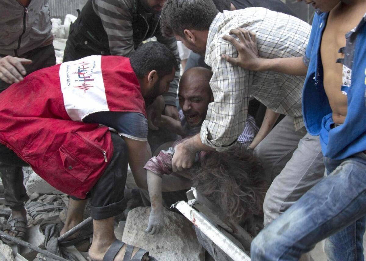 A man cries over the body of his child after she was pulled from the rubble of a bombed building in a rebel-held neighborhood in Aleppo, Syria, this week.