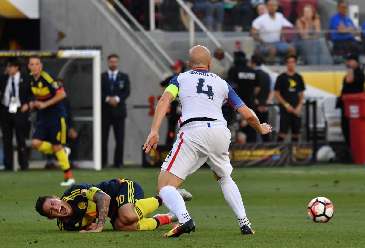 Colombia's James Rodriguez writhes in pain next to Michael Bradley of the United States during Friday's game.