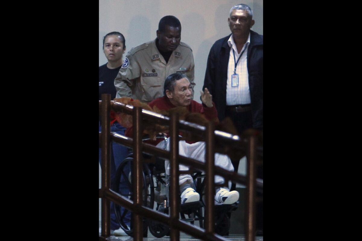 En esta fotografía de archivo del 11 de diciembre de 2011, el exdictador panameño Manuel Antonio Noriega habla mientras un policía lo transporta en silla de ruedas dentro de la cárcel El Renacer en las afueras de Ciudad de Panamá. En declaraciones a la televisión local, el exhombre fuerte panameño rompió su largo silencio en una entreivsta desde prisión, difundida el miércoles 24 de junio de 2015, en la que pidió a sus compatriotas que perdonaran las acciones de los miltiares que culminaron en la invasión estadounidense de 1989. (Foto AP/Esteban Félix, archivo)